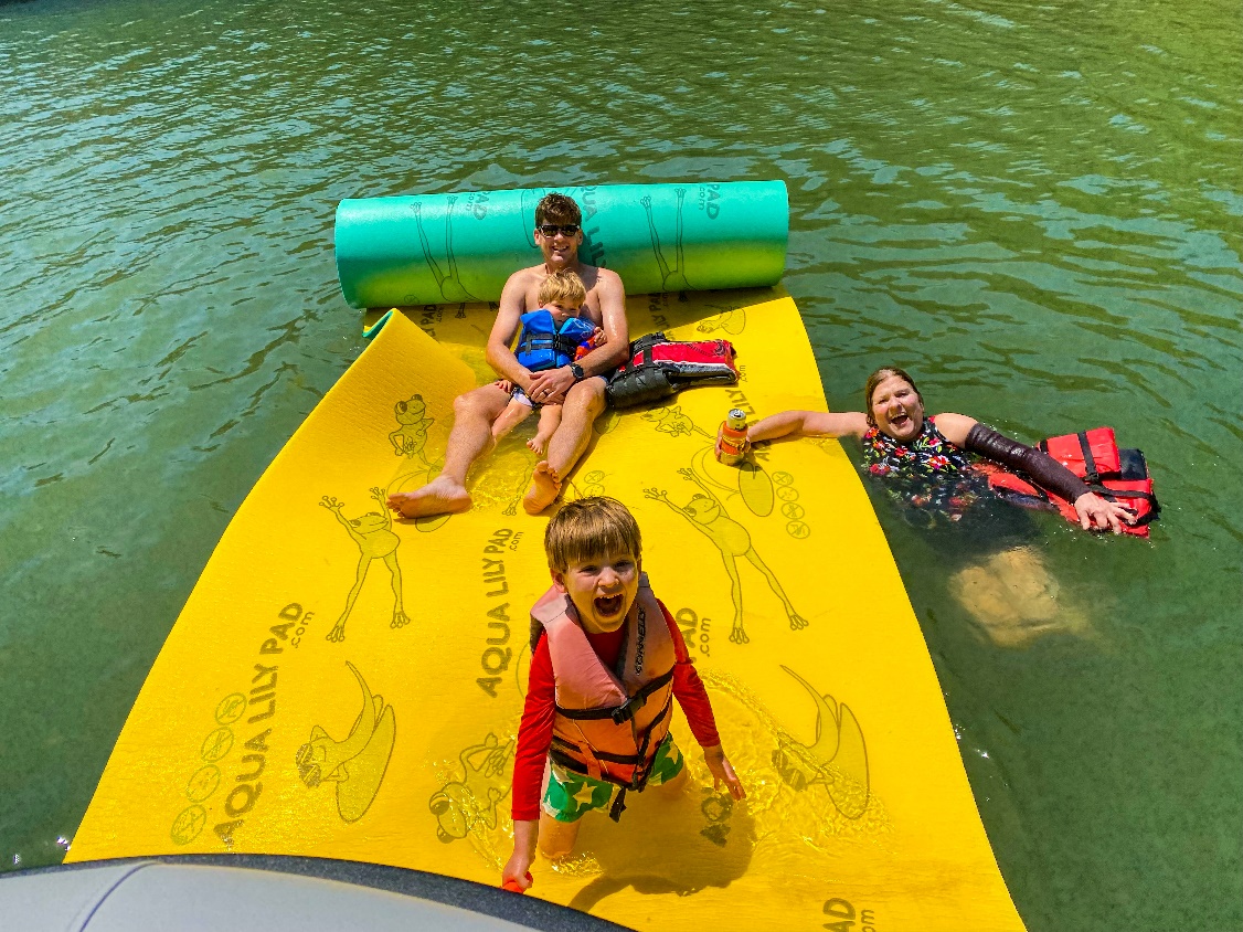 Kids playing on a yellow aqua lilypad.