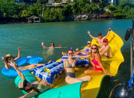 : People sitting on a lilypad on Lake Austin.