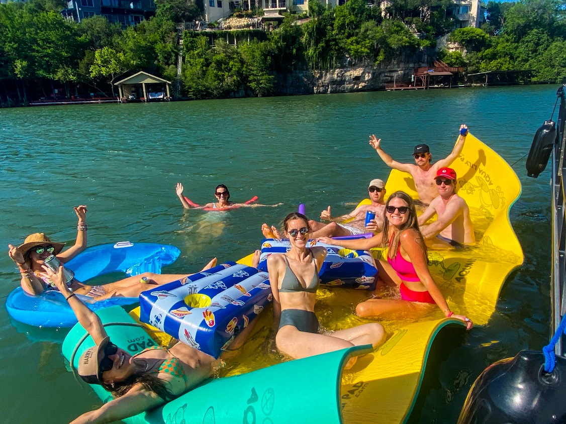 : People sitting on a lilypad on Lake Austin.