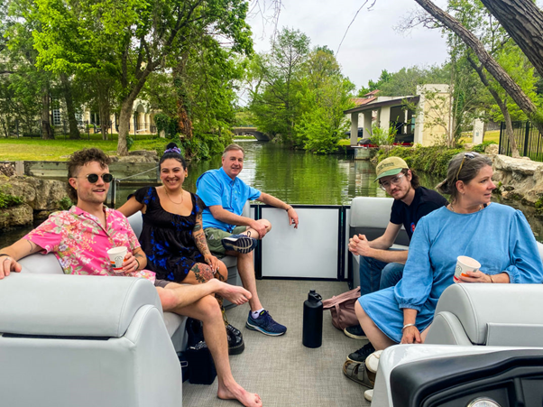 A group of office colleagues in a boat on Lake Austin