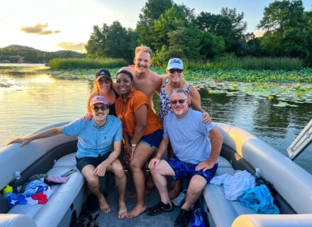 Wake Riderz boat on Lake Austin with smiling passengers enjoying the water activities.