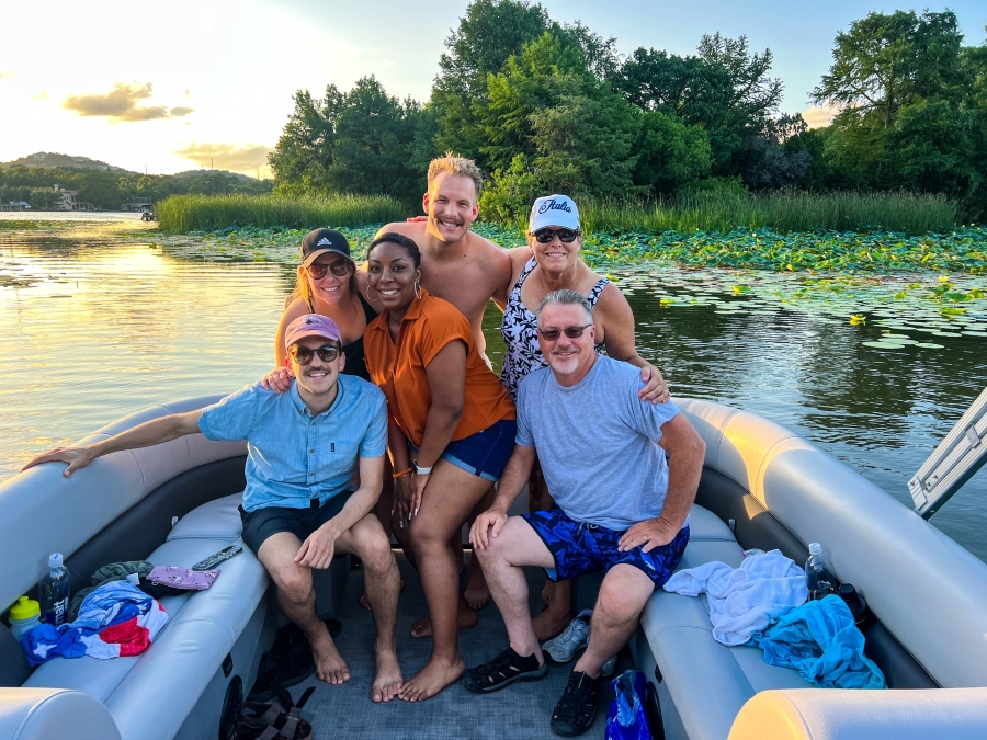 Wake Riderz boat on Lake Austin with smiling passengers enjoying the water activities.