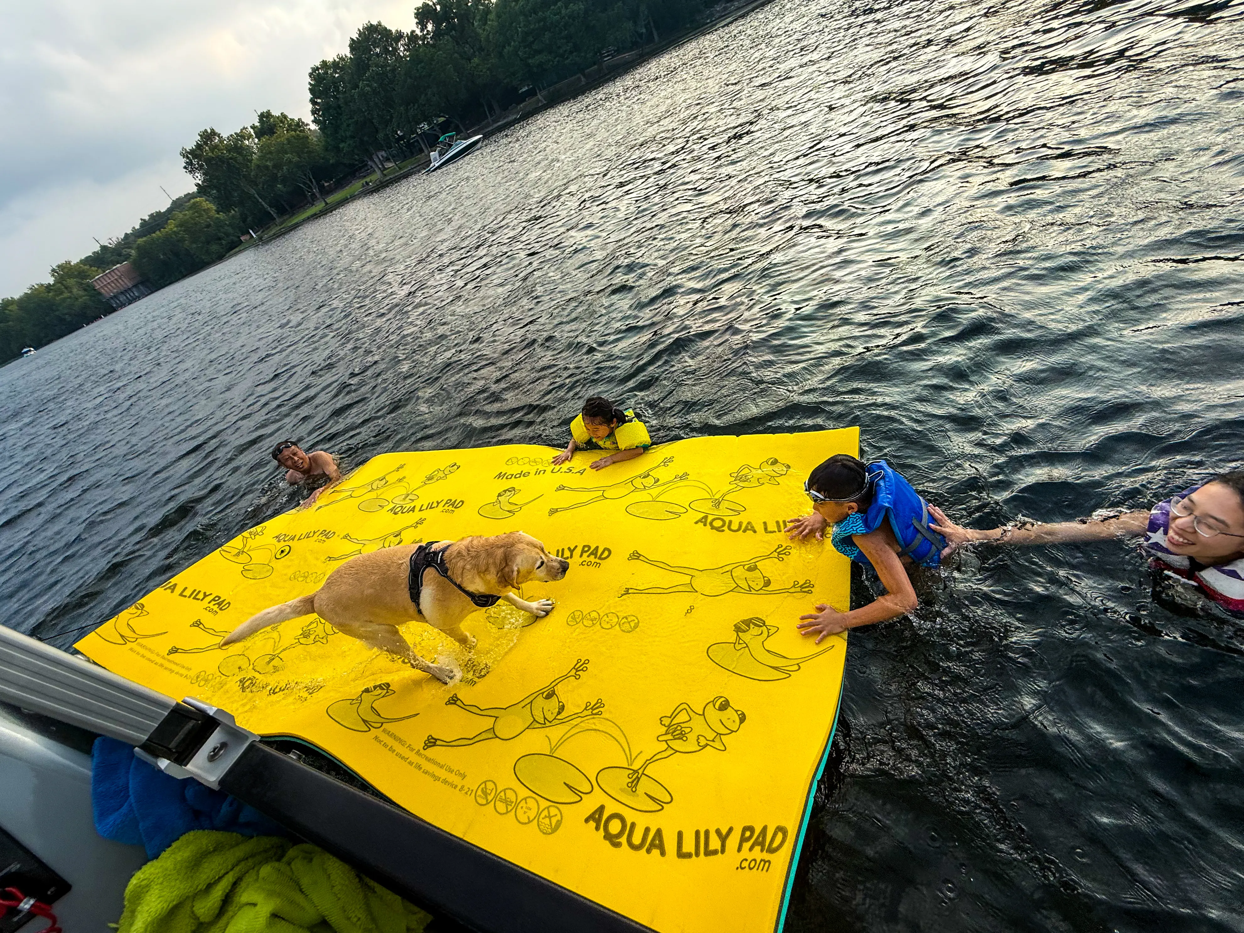 Family swimming and relaxing on a floating water mat during a Lake Austin boat rental