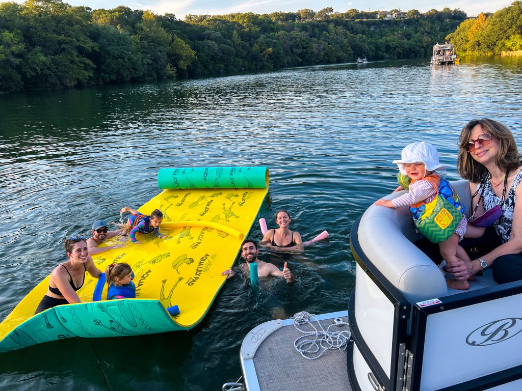 A family enjoying the Aqua Lily Pad on their Lake Austin boat rental service.