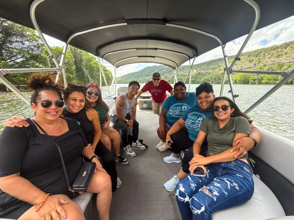 A group of friends and fellow travelers socializing on a Wake Riderz public boat tour on Lake Austin.