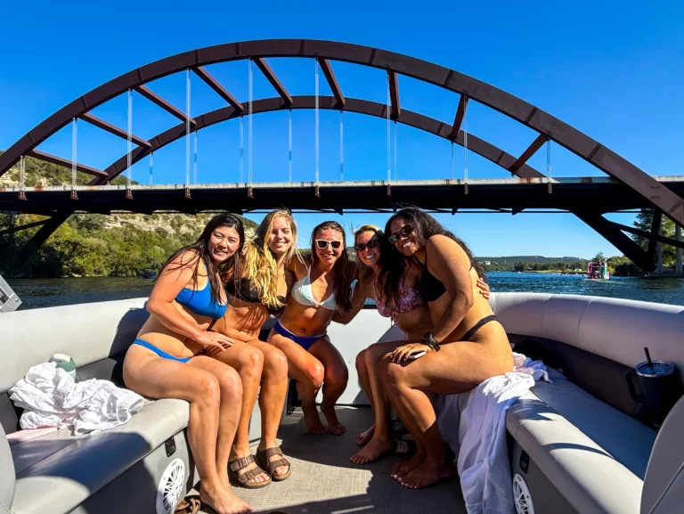 Group of women celebrating a fun outing beneath the Pennybacker Bridge during a captained Lake Austin boat tour