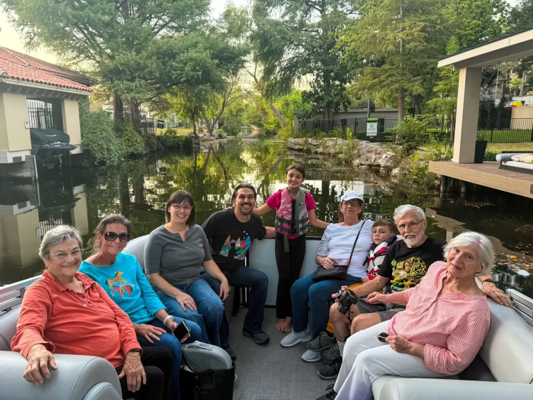 Family enjoying a peaceful captained pontoon tour through a scenic canal on Lake Austin known as Little Venice or Little Italy
