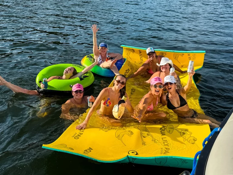 Group of women relaxing and celebrating on a floating pad during a Lake Austin captained boat party