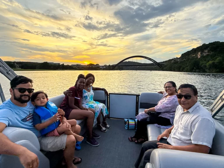 Family and friends relaxing during a peaceful Lake Austin sunset boat tour near the Pennybacker Bridge