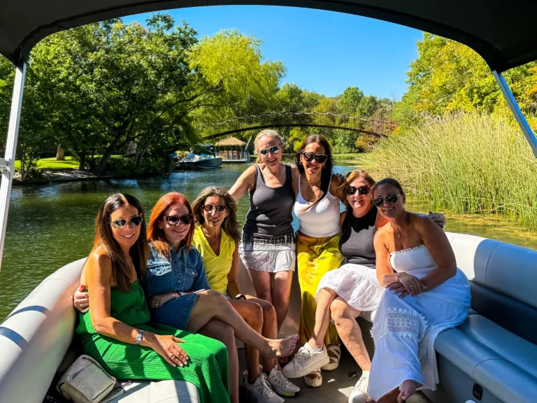 Group of women enjoying a scenic captained pontoon tour through a peaceful canal on Lake Austin