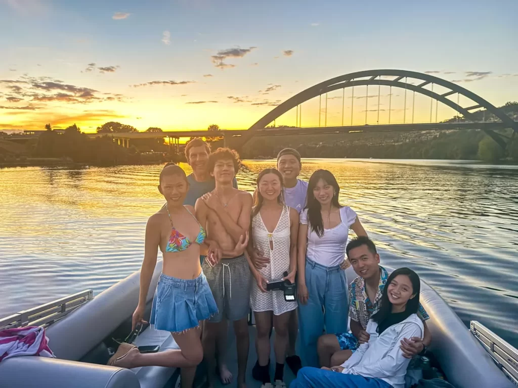 Group enjoying sunset cruise on pontoon boat on Lake Austin near Pennybacker Bridge