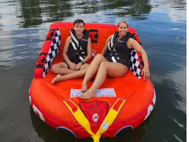 Two girls enjoying water tubing during a Lake Austin boat rental