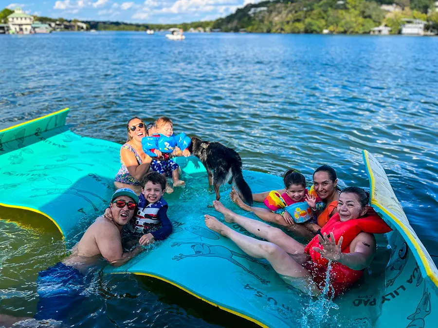 Family enjoying a Lake Austin boat rental with a floating water mat